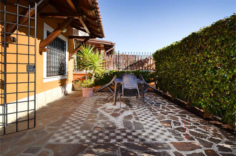 Giardino piastrellato e posto auto scoperto